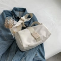 Minimalist white nylon crossbody bag with adjustable thick shoulder strap in a flat lay view - White