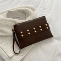 Pochette a busta color caffè scuro con rivetti esagonali dorati e cinturino da polso - Marrone