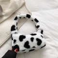 Plush heart print tote bag in black and white cow pattern with soft faux fur texture - Black
