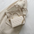 Bolso bandolera beige elegante con costuras de diamante y asa tejida sobre traje - Blanco