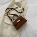 Vintage brown leather crossbody bag with gold rotating lock on a white blazer - Brown