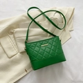 Chic green quilted crossbody bag with gold hardware and chain strap on blazer - Green