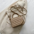 Bolso bandolera acolchado caqui con asa trenzada y detalles dorados sobre blazer beige - Caqui