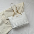 White quilted tote bag with checkered pattern and gold chain strap on blazer - White