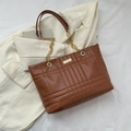 Brown quilted tote bag with gold chain strap and metal logo plate on white fabric - Dark Brown