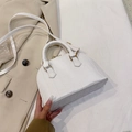 White faux leather dome bag with crocodile texture and golden metal hardware - White