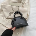 Bolso de mano negro en cuero granulado con correa de cadena y asas superiores - Negro