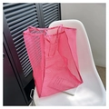 Detalle del bolso tote de malla rosa que muestra la textura transpirable en silla - Rosa rojo