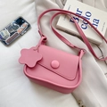 Borsa a tracolla rosa opaca con fibbia rotonda e ciondolo a fiore su sfondo di stoffa - Rosa
