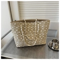 Detalle del bordado floral blanco en un bolso tote de paja color beige natural - Caqui