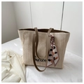 Detail of straw tote bag featuring Summer embroidery and a stylish printed silk scarf - Coffee