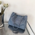 Große graublaue Tote Bag mit Kettenriemen auf einem Metallregal mit Tulpendekoration - Dunkelblau