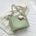 Mint green leather tote bag with silver chain straps and a pink peach plush charm - Green