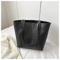 Detalle de bolso tote negro con textura acolchada en V y elegante acabado en mate - Negro