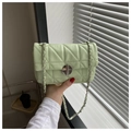 Macro detail of mint green quilted PU leather bag with silver chain strap and metal lock - Green