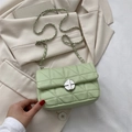 Sac bandoulière vert menthe matelassé avec chaîne et fermoir doré sur un blazer beige - Style Matelassé Triangulaire / Vert