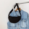 Detail of a minimalist black half-moon nylon crossbody bag with adjustable strap - Black