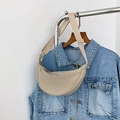 Detail of beige half-moon crossbody bag styled with a blue denim jacket on wood hanger - Off White