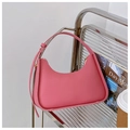 Détail du sac à main en cuir rose sur un support argenté avec accessoires lifestyle - Rose