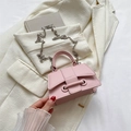 Mini sac rose avec bandoulière chaîne argentée et fermoir unique sur un blazer blanc - Rose