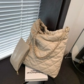 Beigefarbene Stepptasche mit Kettenriemen auf einem Holztisch in modernem Stil - Khaki
