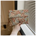 Close-up of floral tapestry envelope clutch with golden clover buckle and wrist strap - Little Red Flower