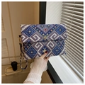 Detail der gewebten Clutch-Tasche mit bunten geometrischen Mustern und Kleeblatt-Verschluss - Blau