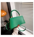Detail van groene trapezium handtas met gouden hardware en handvat in een retro interieur - Groen