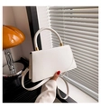Detail van een witte rechthoekige PU-leren handtas met gouden hardware en handvat - Wit