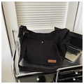 Macro shot of black corduroy shoulder bag showing external pocket and metal magnetic buckle - Black