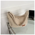 Close-up of beige corduroy tote bag with magnetic snap pocket and fashion leather label - Off White