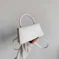 Bolso de mano blanco minimalista con herrajes dorados y asa rígida circular - Blanco