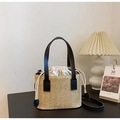 Detalle del bolso tipo cubo de paja tejida con textura espigada y forro con cordón - Negro