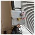 Détail du sac à dos argenté texturé avec fermoir doré et charm monstre rose - Avec Pendentif / Argenté