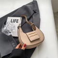 Chic beige crescent hobo bag with gold buckle on a stylish dark blazer backdrop - Khaki