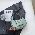 Mint green crescent hobo shoulder bag with wavy golden buckle on stylish grey blazer - Green