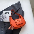Chic orange hobo shoulder bag with golden geometric clasp on dark gray suit fabric - Orange