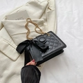 Black quilted shoulder bag with large silk bow and gold chain on beige blazer - Black