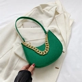 Green croc-embossed hobo bag with a chunky gold chain strap on a beige blazer - Green