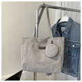 Detalle del bolso tote de pana gris con bolsillo frontal, monedero redondo y etiqueta - Gris
