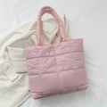 Borsa tote trapuntata rosa con manici imbottiti su sfondo minimalista in tessuto bianco - Rosa