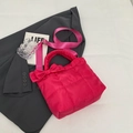Quilted rose red tote bag with bow detail and wide nylon strap on grey blazer - Rose Red