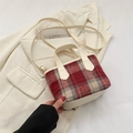 Sac seau à carreaux rouge et gris avec lanières en cuir crème dans un décor de mode - Rouge