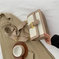 Bolso bandolera minimalista beige y crema con hebilla dorada sobre un traje - Blanco & Caqui