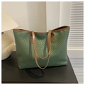 Detalle de bolso tote tejido verde con asas de cuero marrón sobre un fondo minimalista - Verde