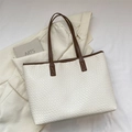 Borsa tote intrecciata bianca con manici in pelle marrone su un blazer beige elegante - Bianco