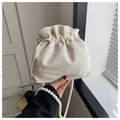 Detalle de bolso cubo en pana blanco crema con textura plisada y cadena de perlas - Blanco