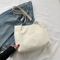 Borsa tote in velluto a coste avorio con toppa in pelle e catena su sfondo denim - Bianco