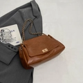 Vintage caramel brown tote bag with gold twist lock and woven chain strap on grey blazer - Brown
