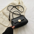 Elegante borsa a tracolla nera con fibbia rotonda dorata e finitura in pelle testurizzata - Nero